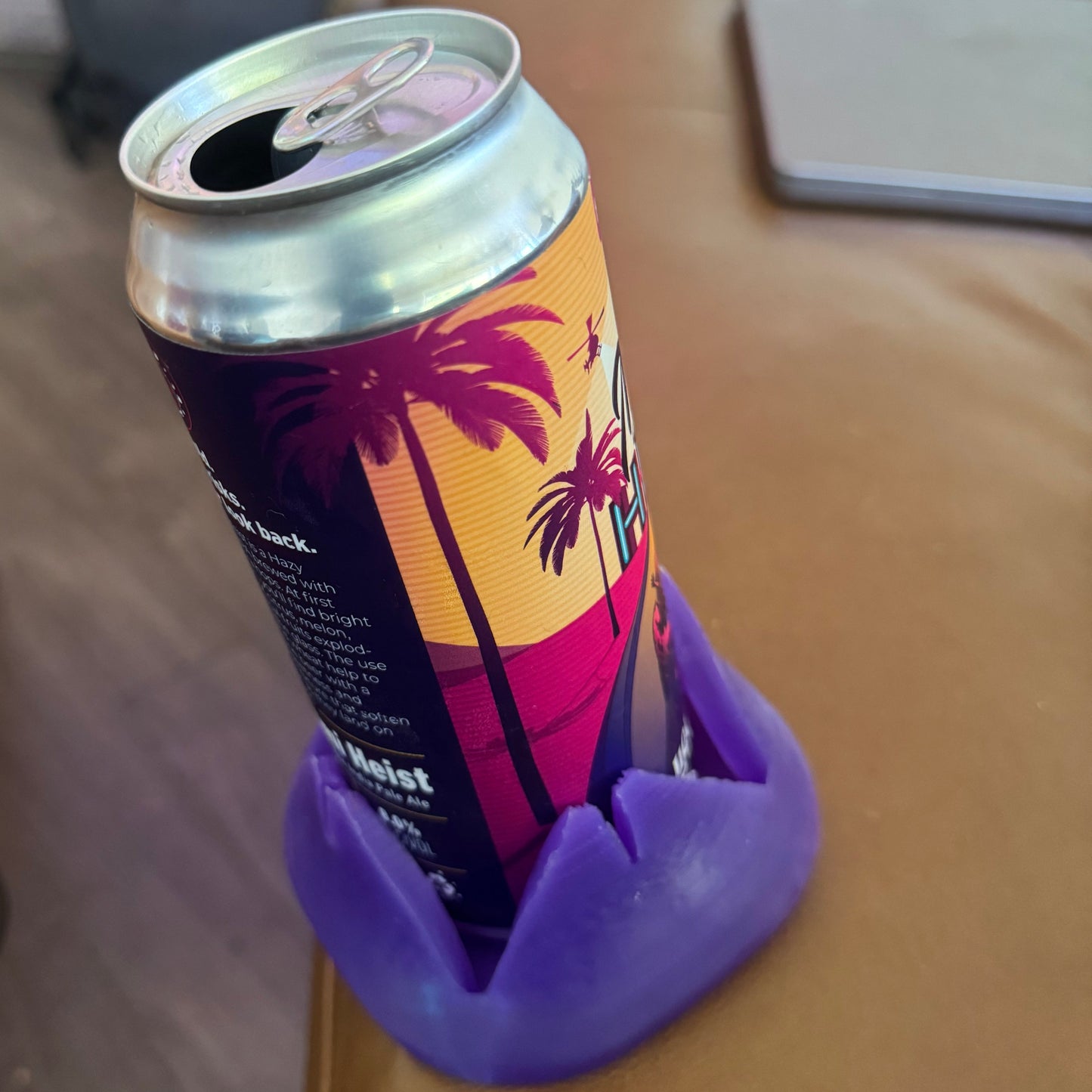 A can with a purple Closer Coaster on the edge of a couch.