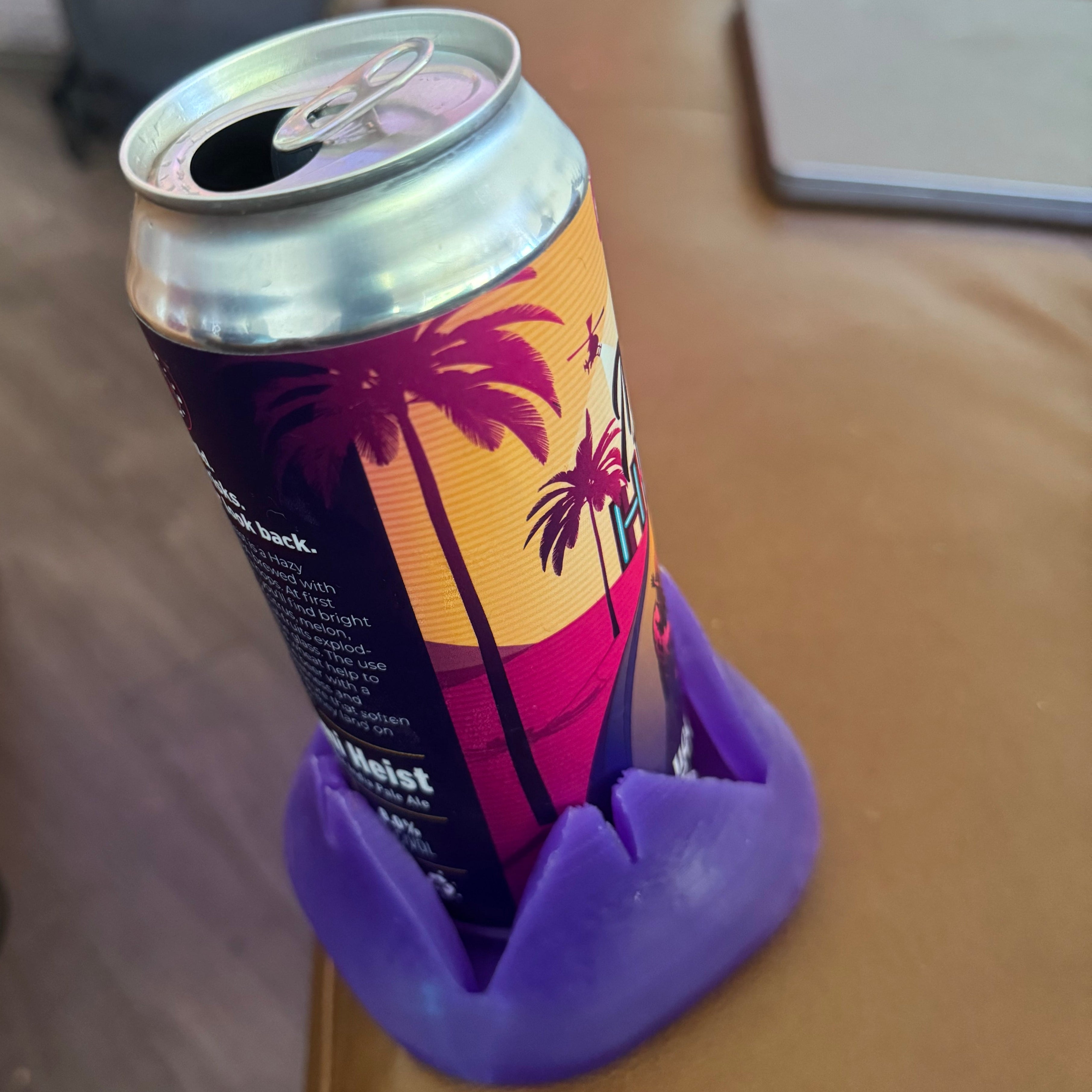 A can with a purple Closer Coaster on the edge of a couch.